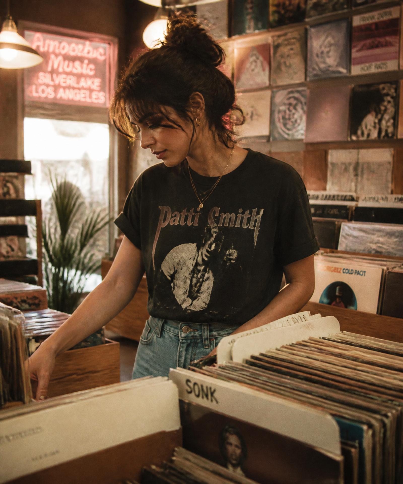 Woman wearing a vintage-inspired band tee browsing records at an independent Los Angeles record store